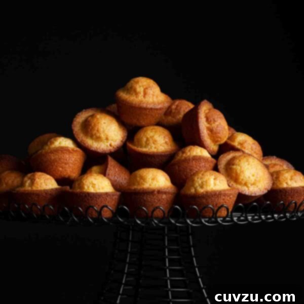 Portuguese mini lemon-orange cakes piled on a cake stand.