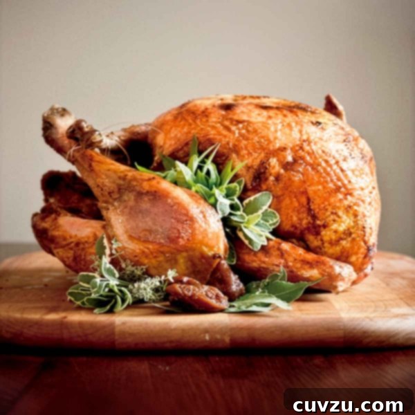 Crispy Golden Fried Turkey 4 A whole deep-fried turkey, garnished with sage, bay, and thyme leaves on a wooden cutting board.