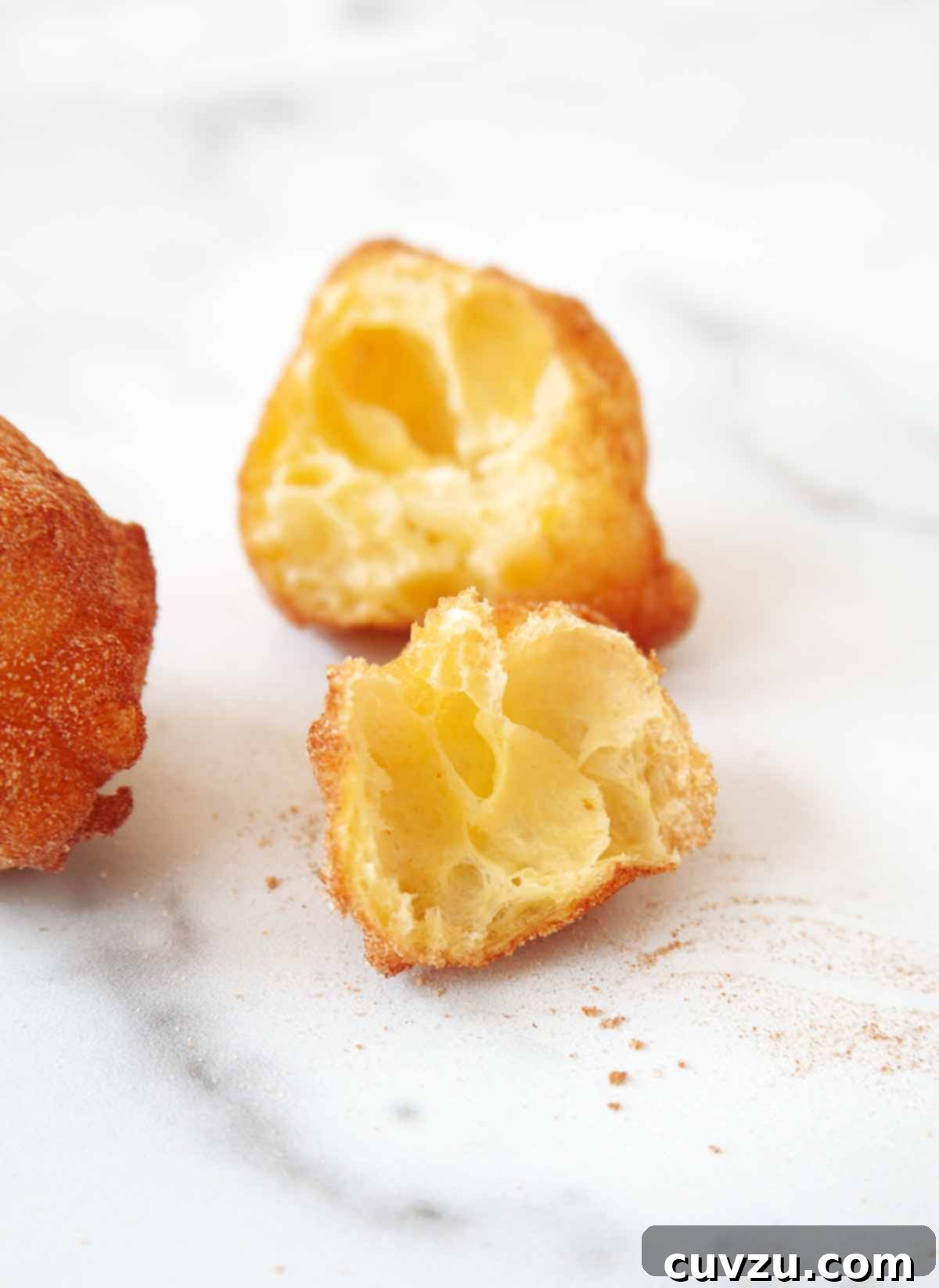 Sonhos: Portugal's Dreamy Doughnuts 3 A Sonho cut in half, showcasing its incredibly light, hollow, and airy interior, a hallmark of this Portuguese doughnut.