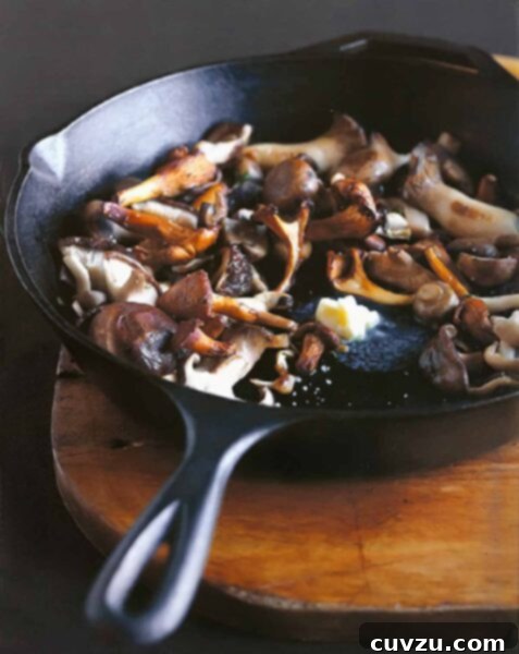 Pan-roasted mushrooms and a knob of butter melting in the center, in a cast-iron skillet