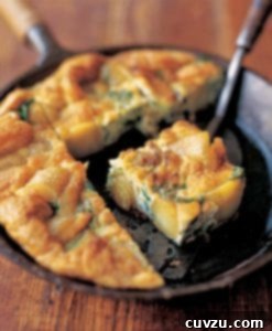 Cast iron skillet of broccolini and potato frittata, with a wedge on a metal spatula