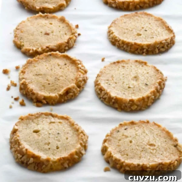 Tangy Stilton Walnut Bites 4 Ten Stilton and walnut crackers arranged in rows on a sheet of parchment.