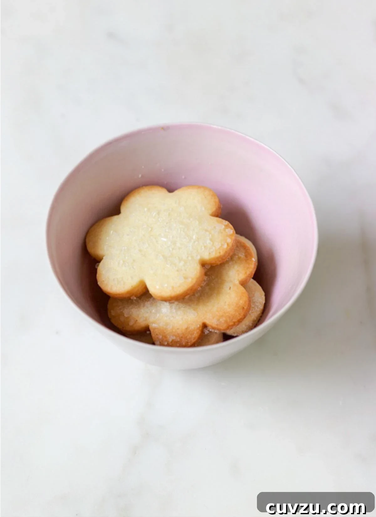 Sweetheart Sugar Delights 2 A pink bowl filled with flower-shaped sugar cookies topped with decorating sugar