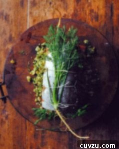 A beautifully presented whole herb stuffed baked salmon, filled with a delicious bread crumb and herb mixture, and tied with kitchen twine, ready to be carved.