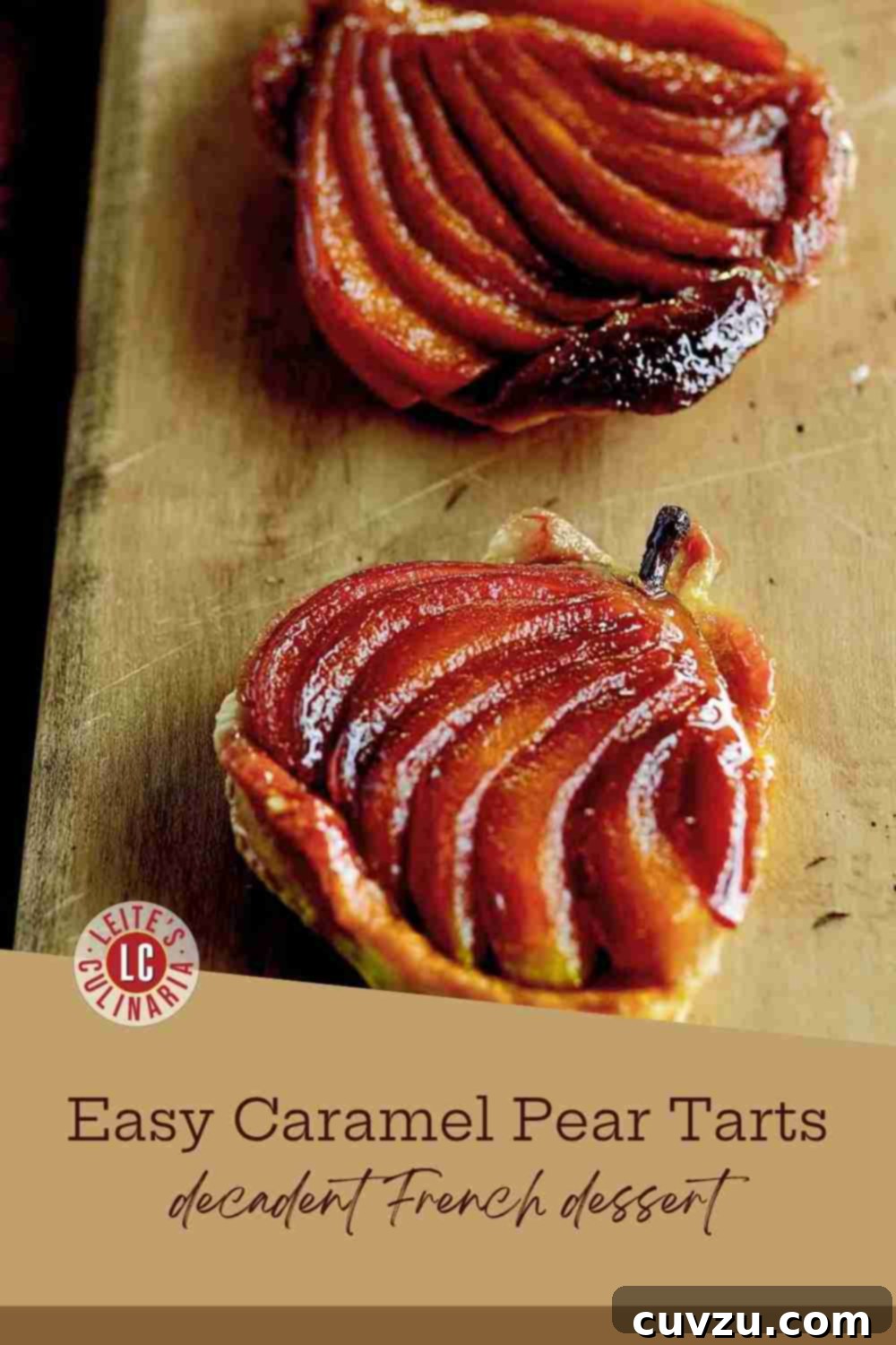 Decadent Pear Caramel Delights 3 Two baked caramel pear tarts inverted on a dark cutting board, showcasing the golden-brown puff pastry and glossy caramel-glazed pears.