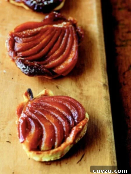 Decadent Pear Caramel Delights 4 Three caramel pear tarts on a wooden board.