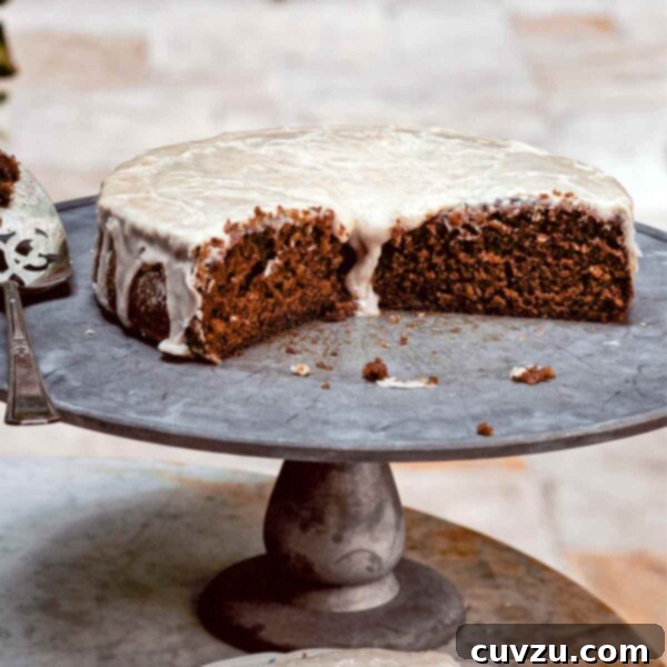 Sweet Cream Root Beer Swirl Cake 3 A cut root beer cake on a pewter platter with a slice on a decorative plate in front, drizzled with a rich glaze.