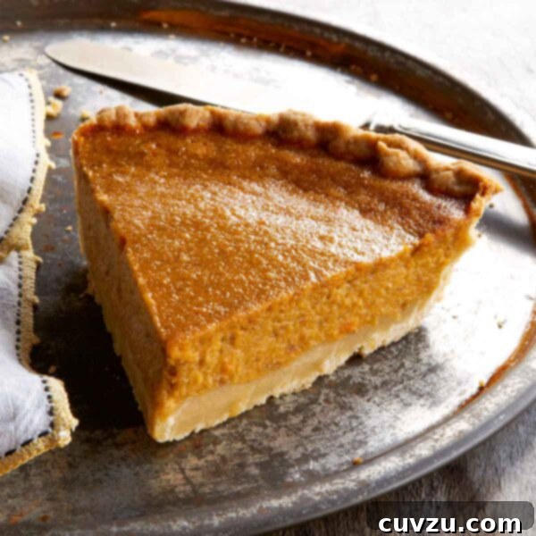 A slice of sweet potato pie on a large metal plate with a napkin and a knife, ready to be enjoyed.