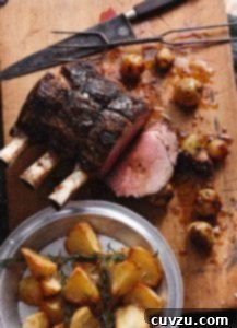 A standing rib roast on a cutting board with caramelized onions