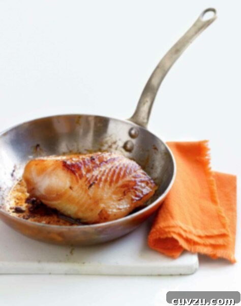 Umami Miso Cod 3 A piece of miso cod in a skillet with an orange napkin next to it.