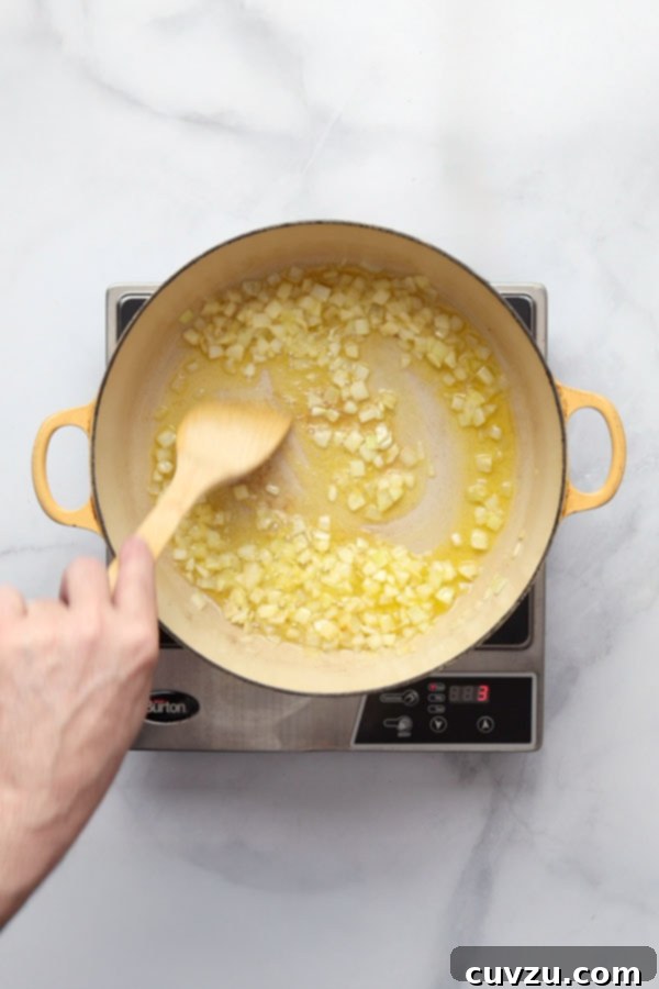 Marcella Hazan's Classic Bolognese 7 Onions sautéing in butter and oil in a large Dutch oven for Bolognese sauce.
