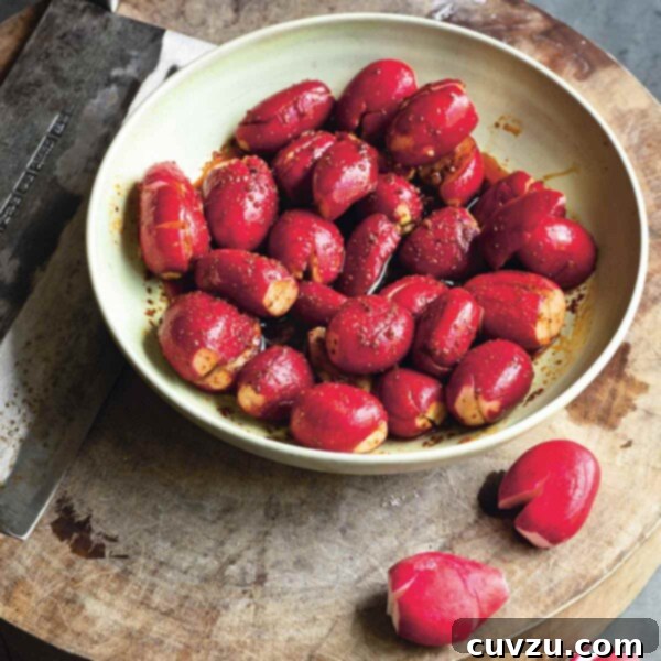 A close-up of a bowl of Radishes in Chile Oil Sauce, showcasing the vibrant red radishes coated in glossy red chili oil.