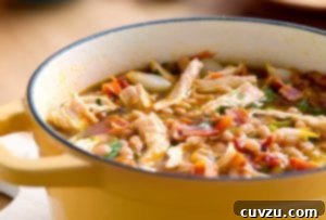 Hearty Chicken and White Bean Chili 3 A yellow Dutch oven filled with white bean and chicken chili, topped with pieces of bacon.