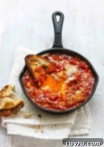 Spicy eggs in hell in a small cast-iron skillet, and half a piece of toasted bread.