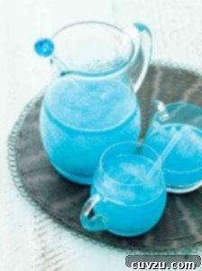 A pitcher and two glasses of blue margarita on a grey woven placemat.