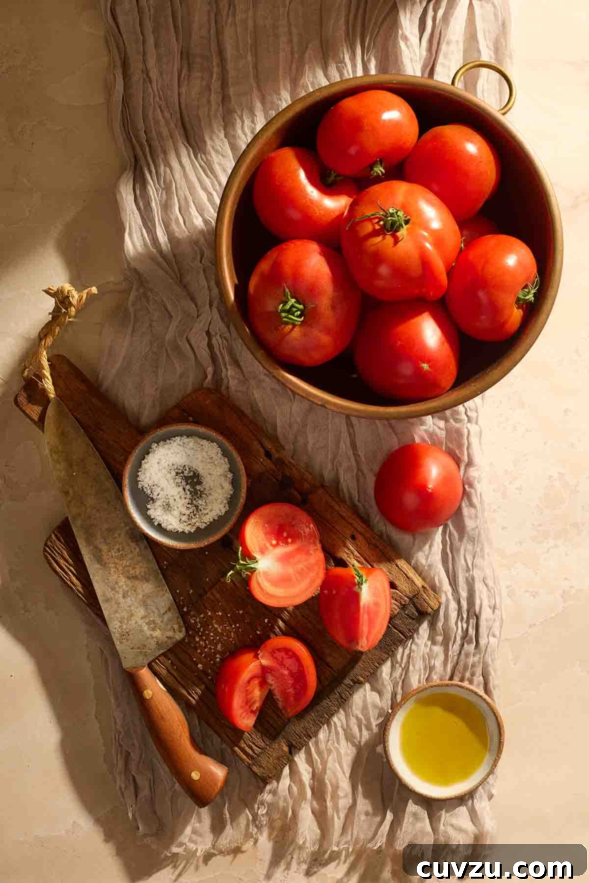 The Art of Homemade Tomato Paste 4 Ingredients for tomato paste, including fresh tomatoes, salt, and olive oil on a wooden board.