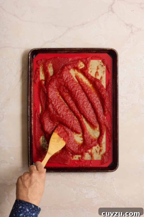 The Art of Homemade Tomato Paste 10 Stirring the tomato paste on the baking sheet partway through the baking process to ensure it dries evenly.