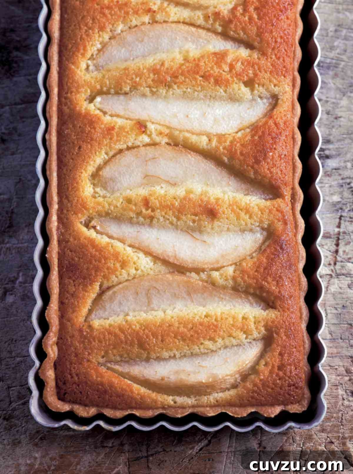 Golden Pear Almond Tart 2 A rectangular tart with wedges of pear baked into it in a rectangular tart pan, showcasing the golden crust and beautifully arranged fruit.