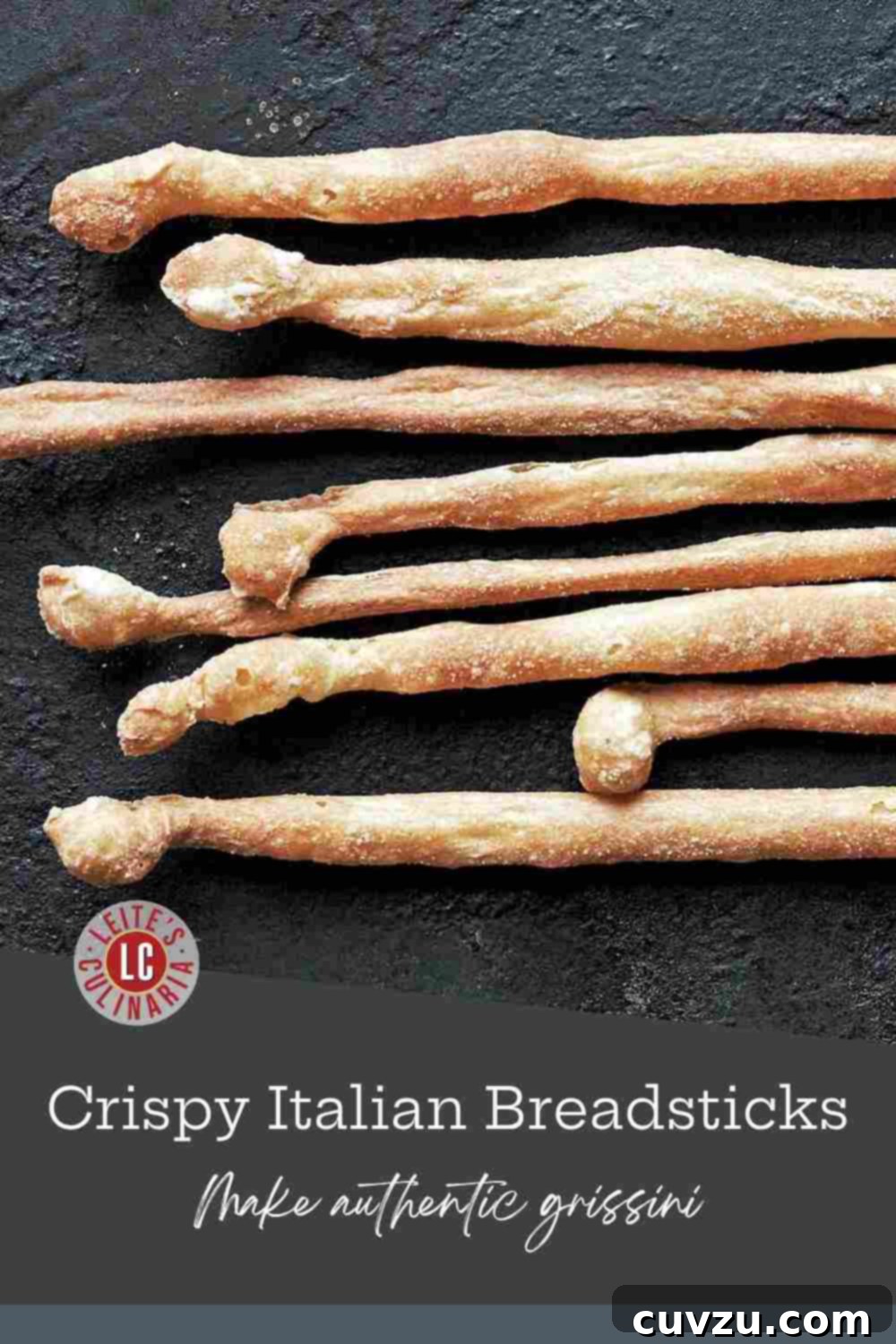 Artisan Italian Breadsticks 3 Crispy, homemade Italian grissini breadsticks dusted with cornmeal, fanned out on a textured, rustic stone surface.