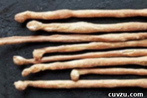 Artisan Italian Breadsticks 4 Eight Italian breadsticks, or grissini, lined up next to each other.