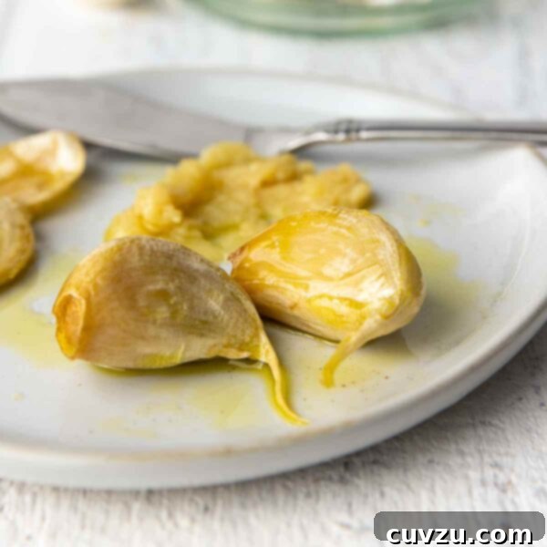 Golden Garlic Velvet 9 Garlic confit cloves on a plate.