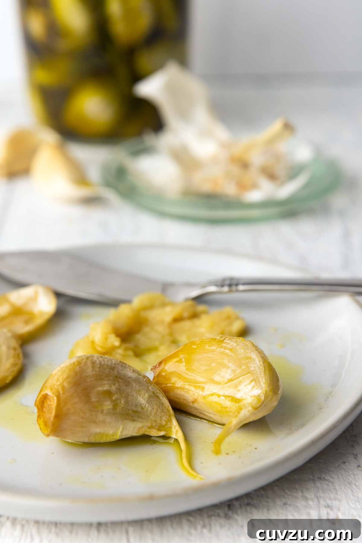 Golden Garlic Velvet 8 A simple white plate holding a small pile of golden, tender garlic confit cloves, ready to be enjoyed or incorporated into a meal.