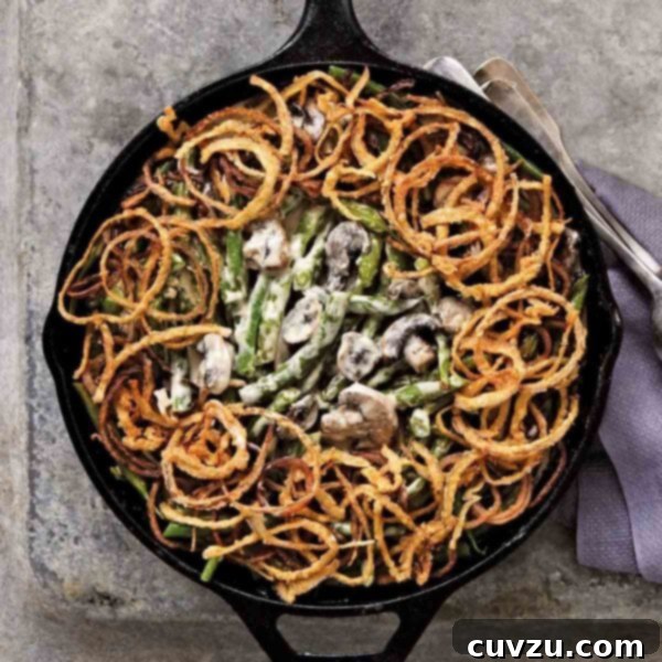 Quintessential Green Bean Casserole 5 A classic green bean casserole with mushrooms and topped with fried onion rings in a cast-iron skillet.