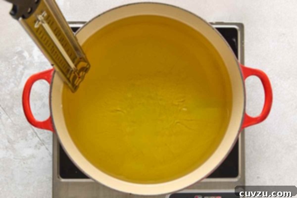 Effortless Extra Crispy Batter Fried Chicken 22 A large pot of oil heating on a burner.