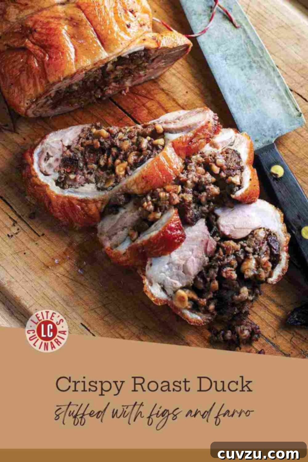 Golden Roast Duck with Farro, Fig & Hazelnut Stuffing 3 Slices of crispy-skinned roast duck breast and dark meat, featuring a farro, fig, and hazelnut stuffing, resting on a dark wood cutting board.