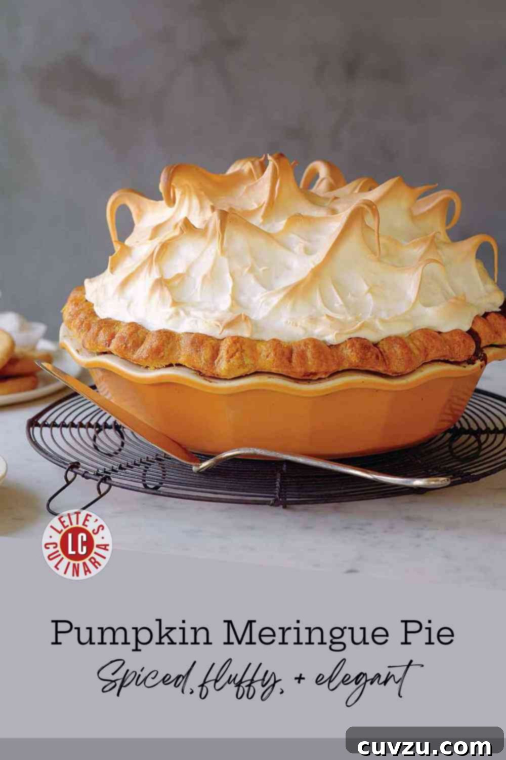 A gorgeous pumpkin pie topped with tall, toasted meringue swirls cooling on a wire rack.