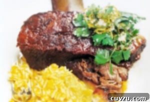 Braised short ribs on a plate with pumpkin orzo, garnished with parsley