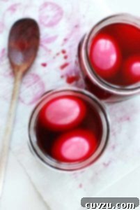 Two Mason jars filled with pickled eggs in beat brine, ready to be enjoyed.