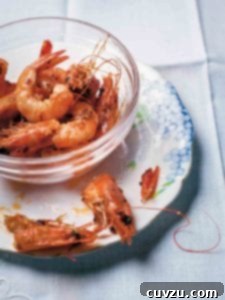 Glass bowl filled with garlic shrimp, sautéed with oil, butter, chiles pepper, and garlic