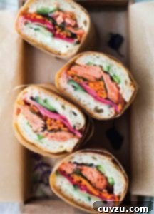 Flaky Salmon Vietnamese Sub 2 Four pieces of salmon banh mi wrapped in paper in a box.