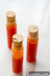 Three corked vials of homemade hot sauce, ready for serving.