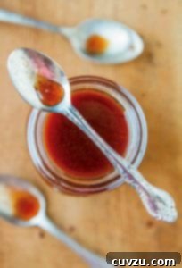 Autumn Harvest Nectar 4 A jar of pumpkin spice syrup with a spoon resting on top and two spoons beside the jar.