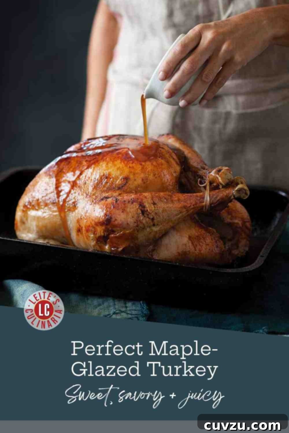 Golden Maple Roast Turkey 3 A glossy, mahogany-brown maple-glazed turkey resting in a black roasting pan as a cook pours on a final layer of glaze.