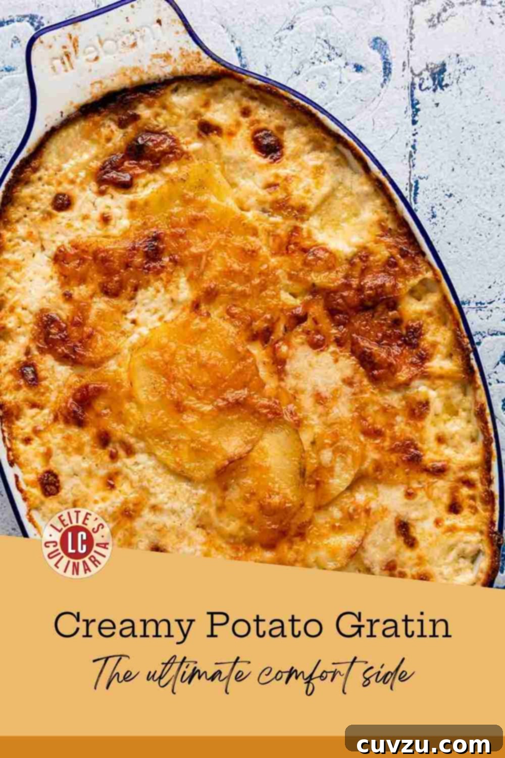 A serving spoon gracefully scoops tender, perfectly cooked sliced Yukon Gold potatoes, glistening in a fragrant garlic-cream sauce, from an elegant oval casserole dish.
