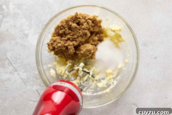 Decadent Egg-Free Chocolate Chip Cookie Dough 13 Butter and sugar being mixed in a glass bowl with a hand mixer.