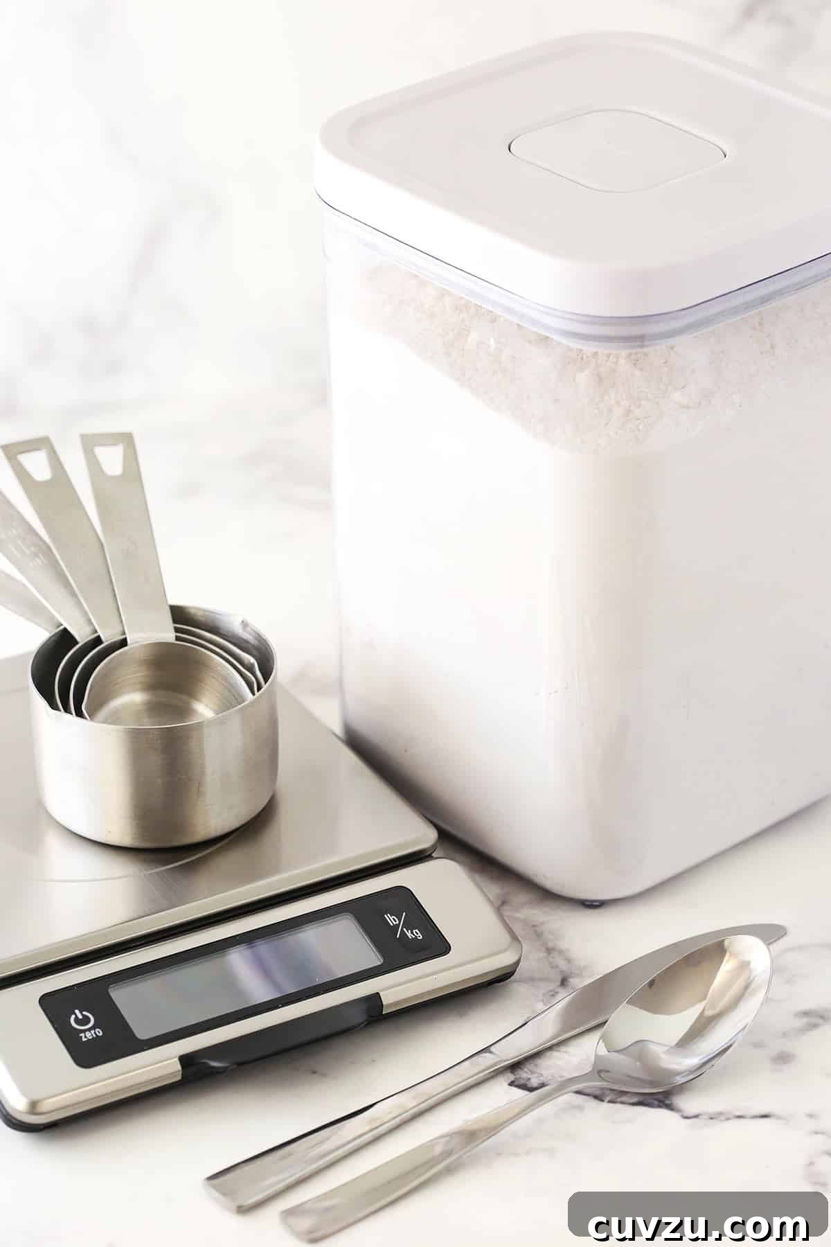 Mastering Accurate Flour Measurement: Your Guide to Perfect Baking Results An array of baking tools for measuring flour, including a digital food scale, measuring cups, and a container of all-purpose flour, demonstrating accuracy in baking.