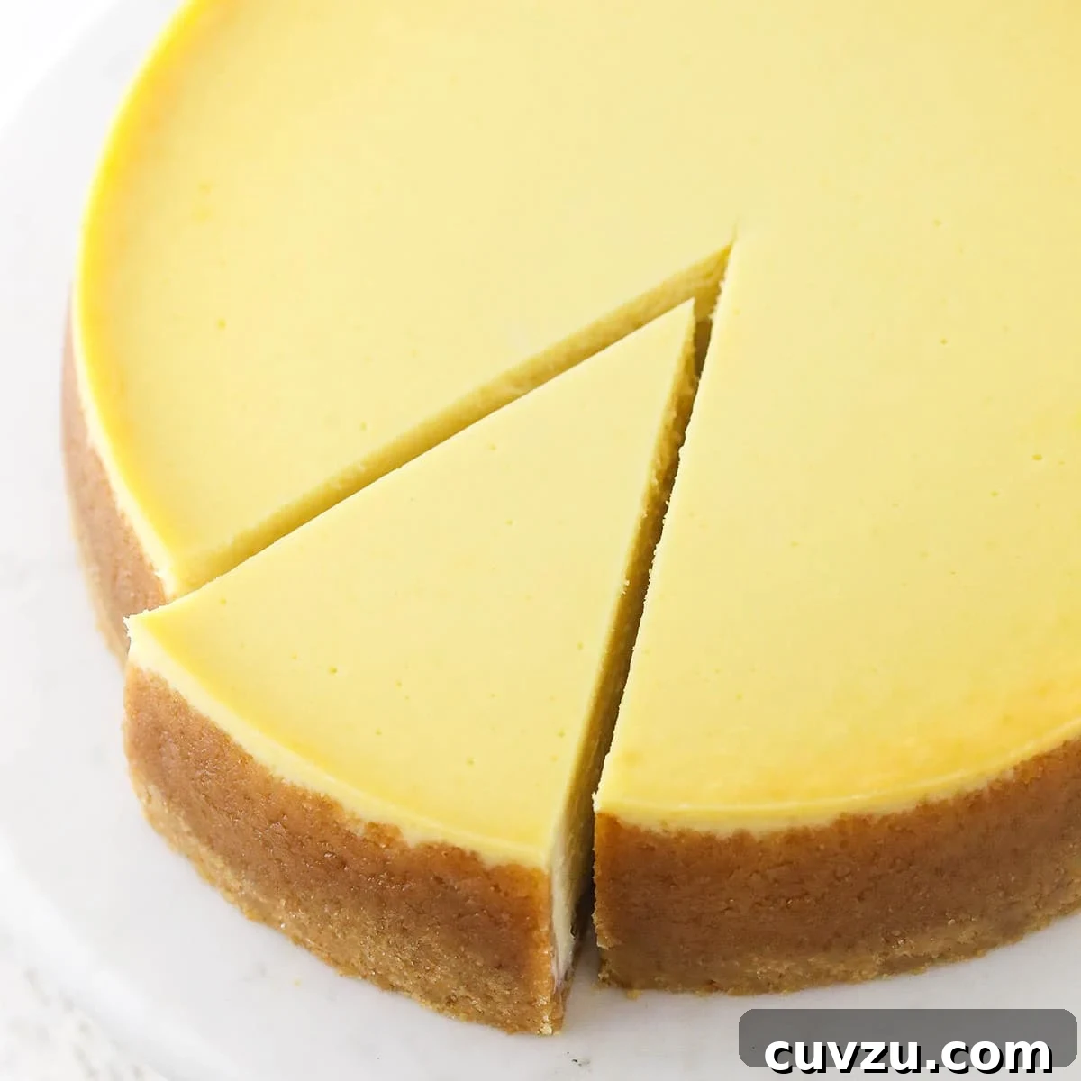 Your Guide to Perfect Cheesecake Doneness 2 a full vanilla cheesecake with a slice cut and slightly removed