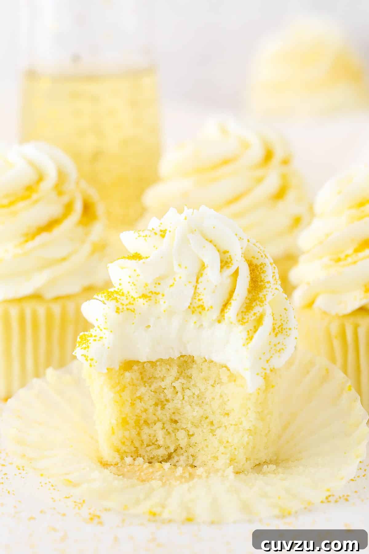 Versatile Champagne Cupcakes for Any Special Occasion A Champagne Cupcake with a bite taken out and three more Champagne Cupcakes in the background