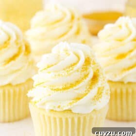 Four Champagne Cupcakes decorated with buttercream frosting on a white table top