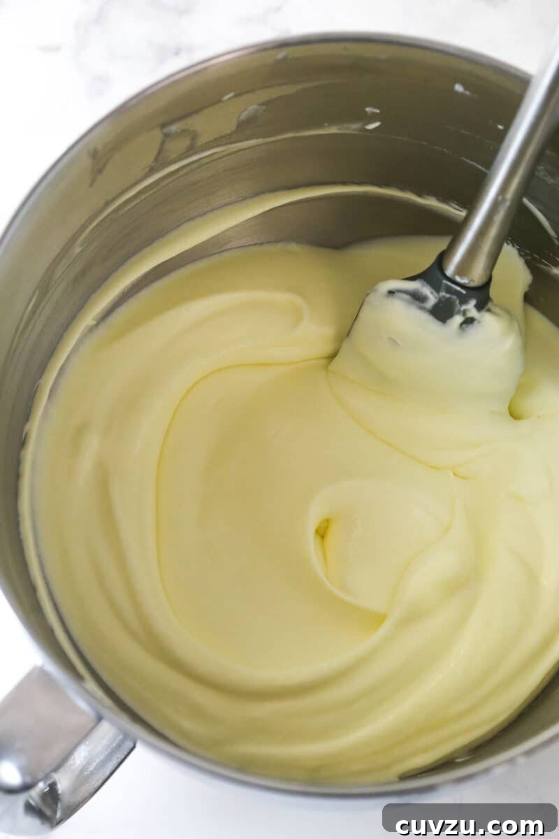 Gently fold whipped cream into the cooled egg mixture. A spatula gently folding the whipped cream into the lighter egg mixture.