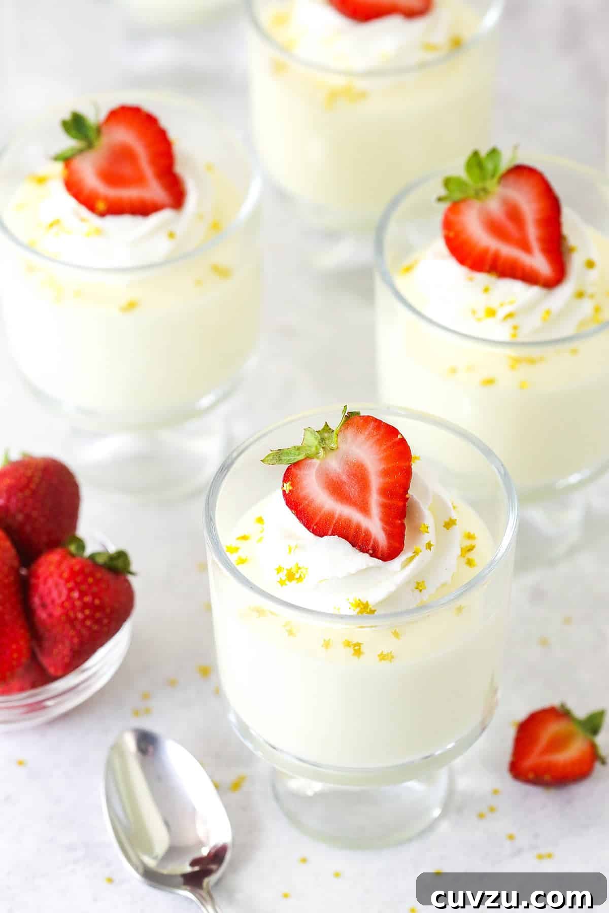 Perfectly chilled Champagne Mousse ready for serving. Overhead view of several glasses of champagne mousse, each topped with whipped cream and a single fresh strawberry.
