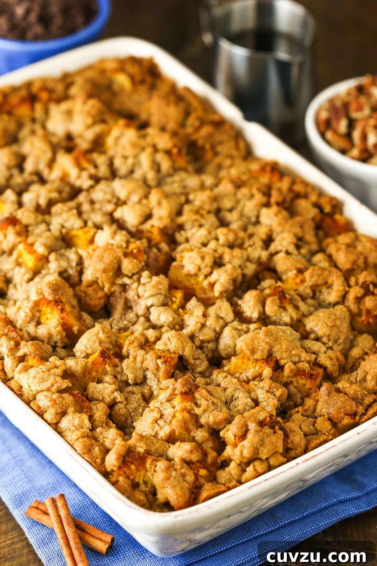 A stunning full platter of Overnight Pumpkin French Toast Casserole, perfect for sharing. Overhead view of a full Overnight Pumpkin French Toast Casserole in a white platter, generously topped with streusel and ready to serve.