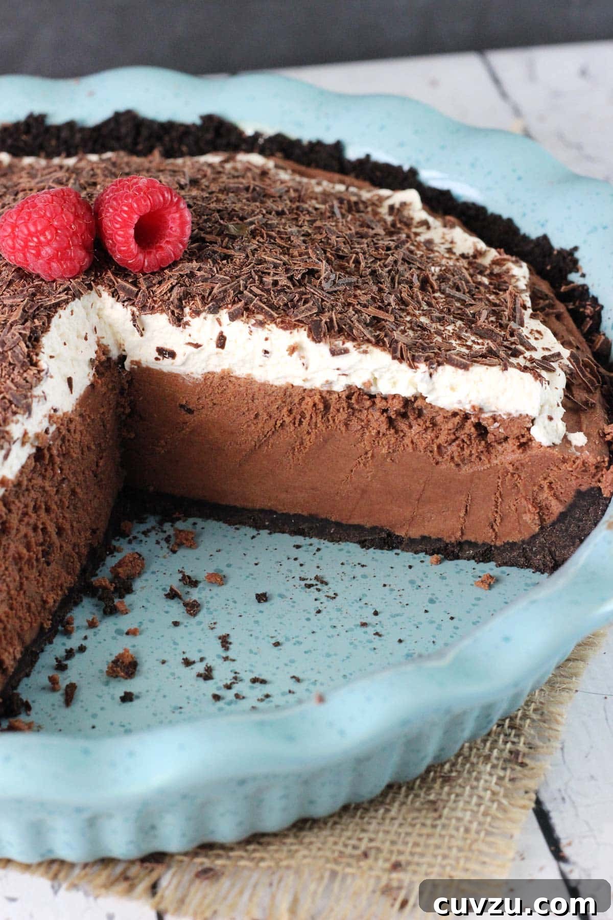 Decadent Chocolate Truffle Pie 3 A chocolate truffle pie in a blue ceramic pie plate with slices removed to show layers.