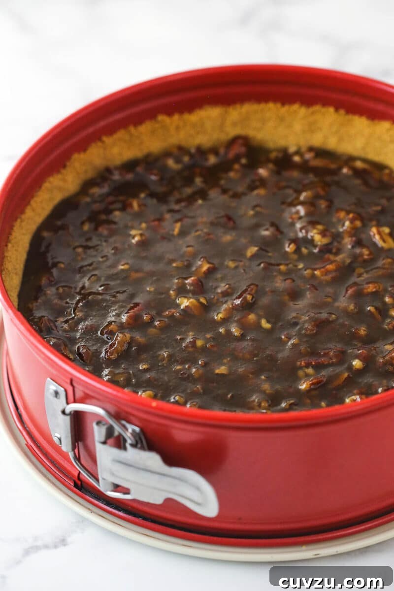 Pecan pie cheesecake combines all of the goodness of classic pecan pie with a smooth, creamy cinnamon cheesecake filling. Pecan pie filling poured into the graham cracker crust within a springform pan.