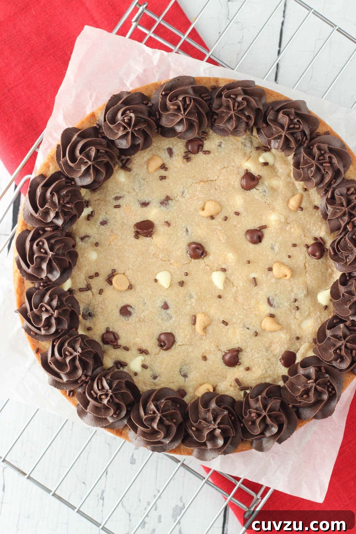 Ultimate Triple Chocolate Chip Cookie Cake 3 An inviting overhead view of a perfectly baked and decorated Triple Chocolate Chip Cookie Cake, garnished with extra chocolate and peanut butter chips.