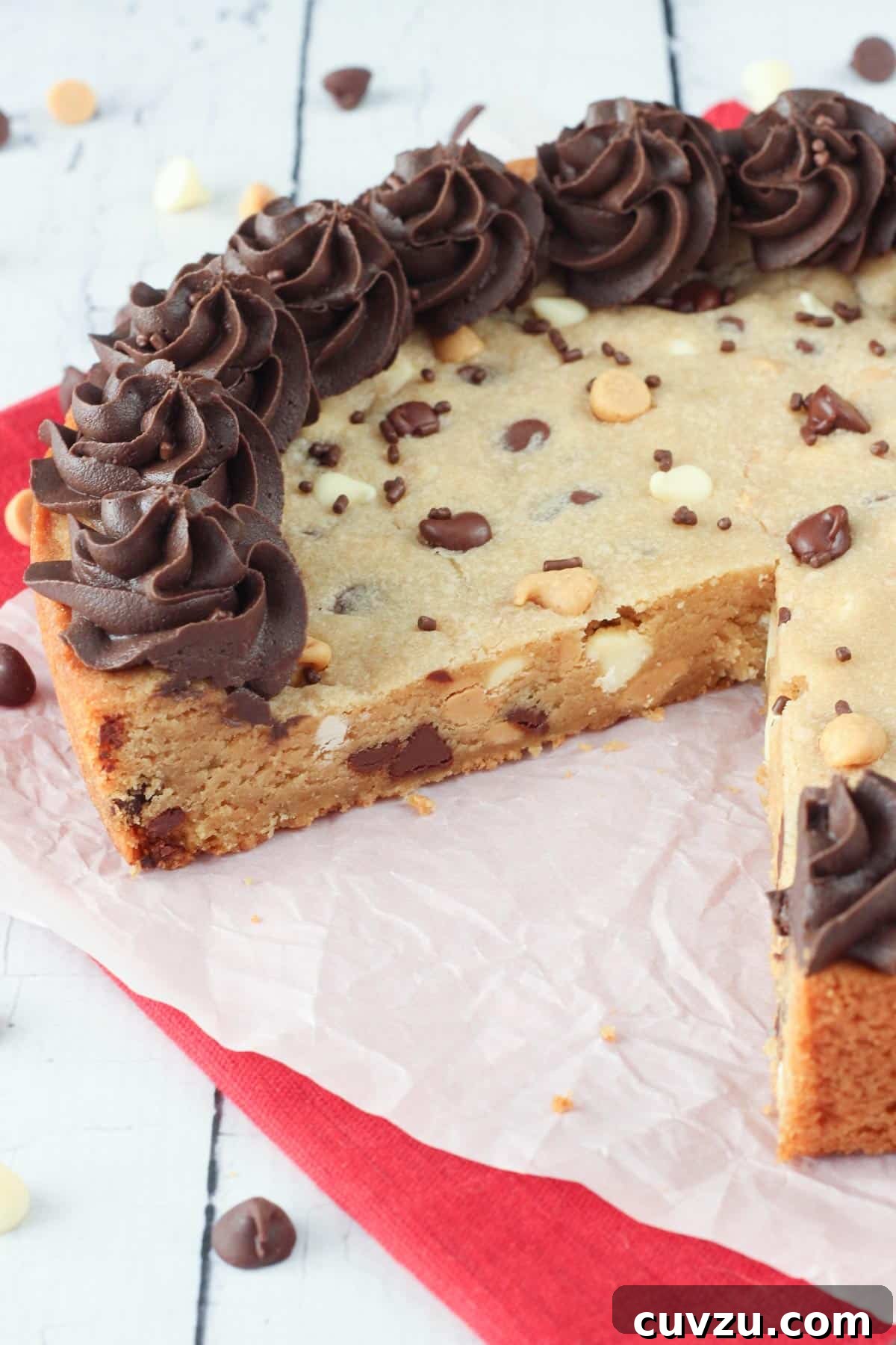 Ultimate Triple Chocolate Chip Cookie Cake 6 A Triple Chocolate Chip Cookie Cake with one slice carefully removed, giving a clear view of its moist, dense crumb and the generous distribution of three types of chips throughout.